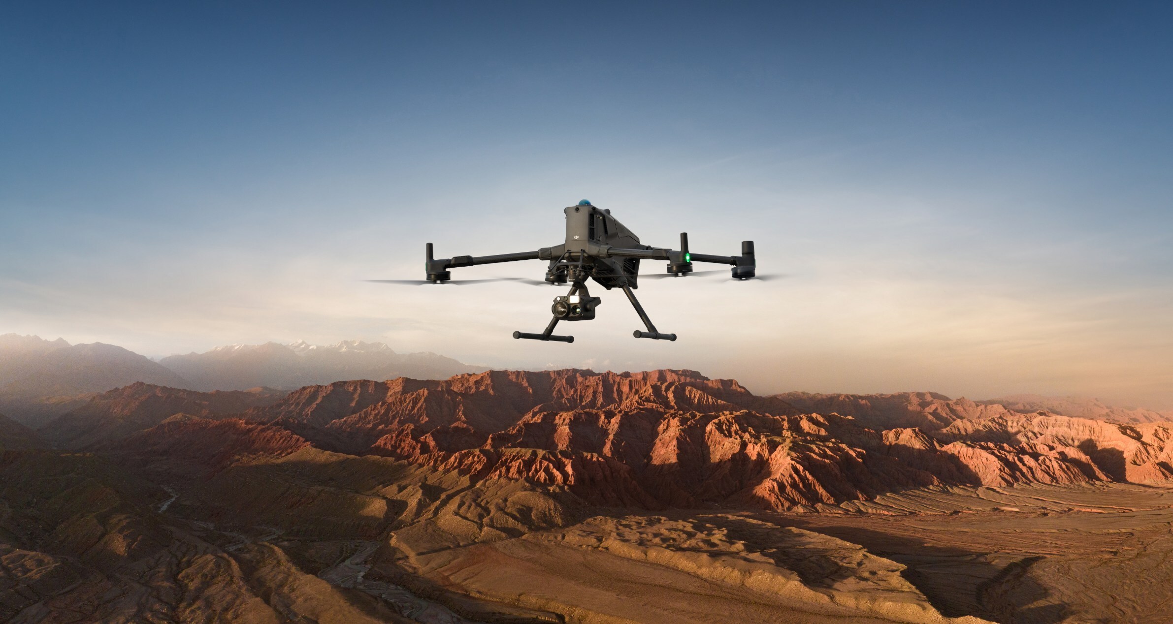 DJI Matrice 400 enterprise quadcopter in flight with multi-sensor gimbal, tall landing gear and skid feet